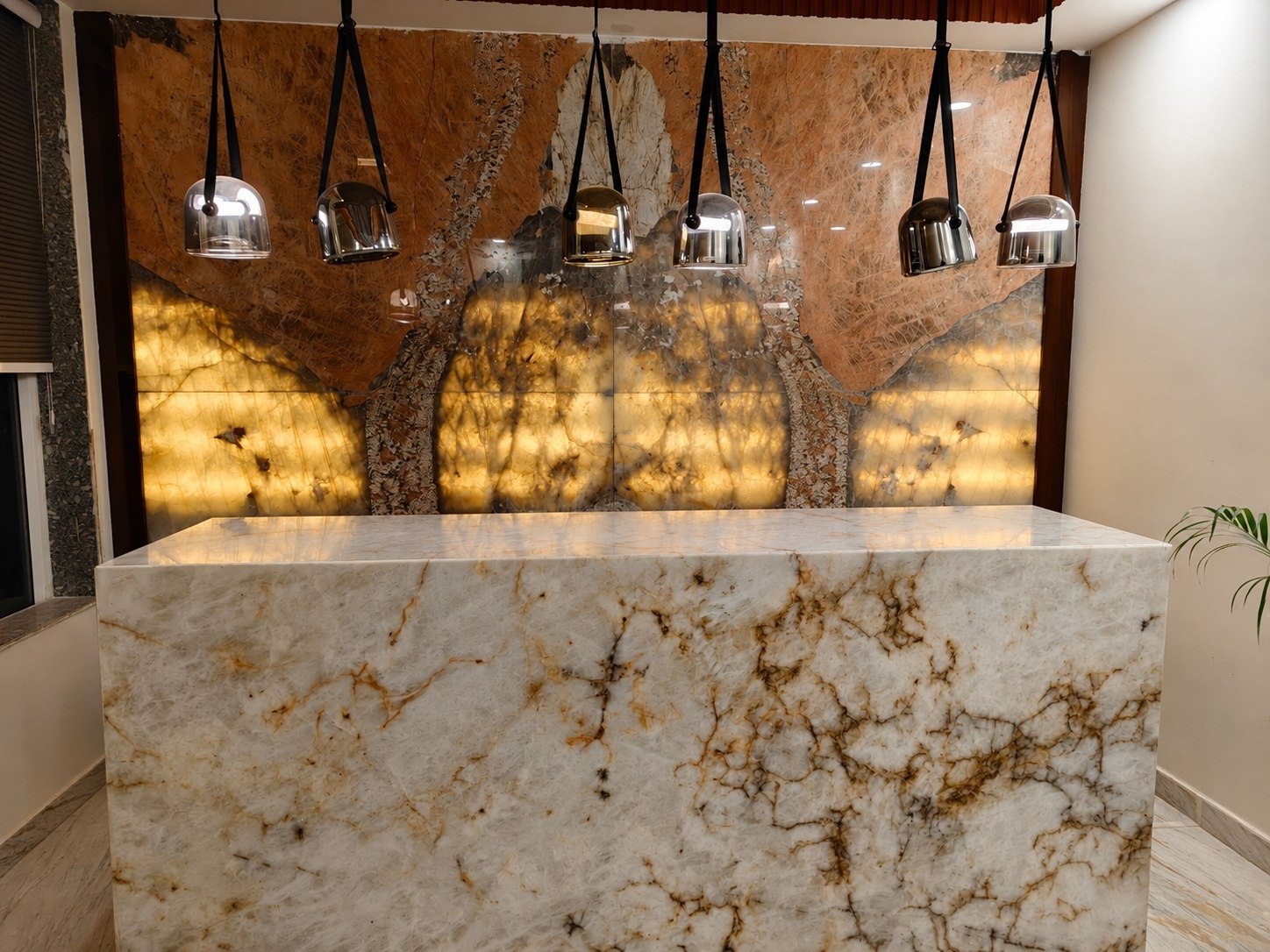 Backlit onyx feature wall with monolithic stone island